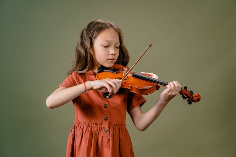 A young girl playing a violin